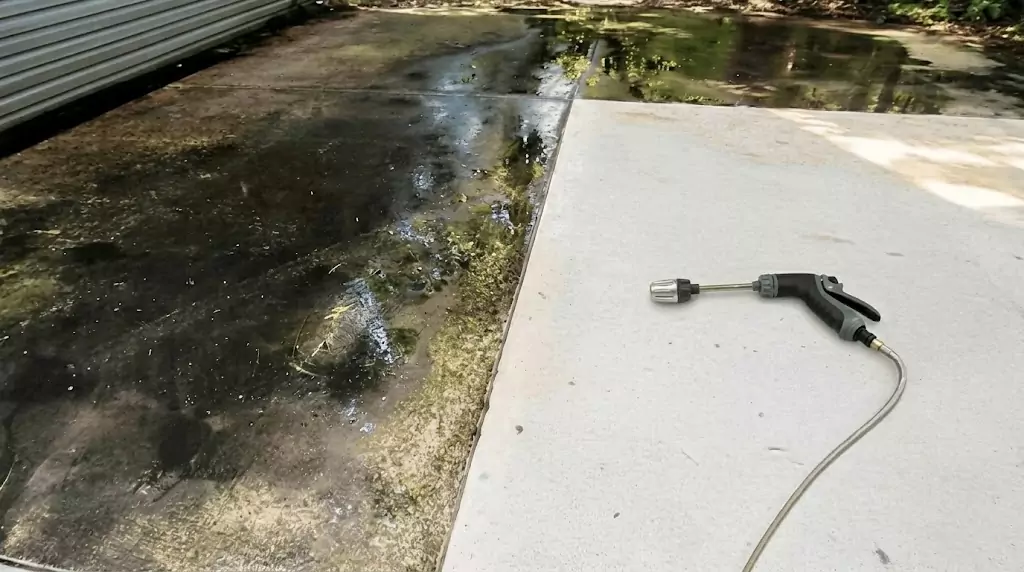 Test Jetterix sur une bande de béton étroite avec des années d'accumulation d'algues — trace nette à travers la zone sale